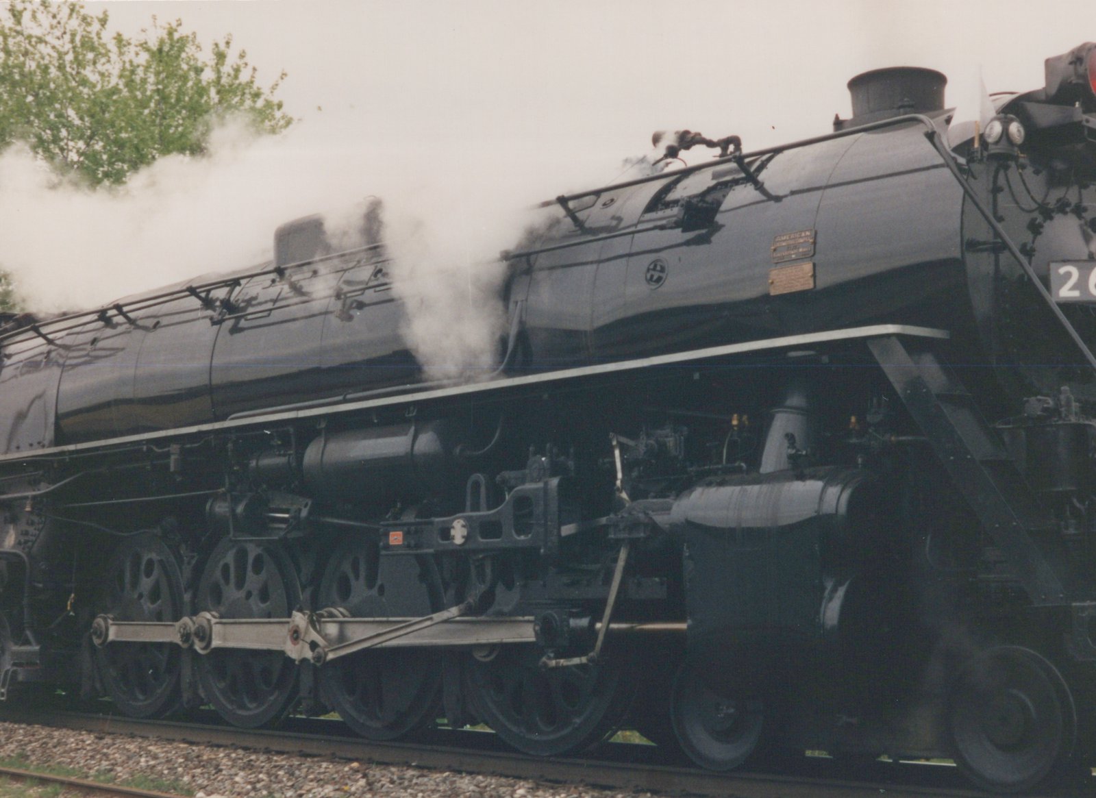 Side view of a black steam locomotive with a round CB&Q herald on its side, showing its number 26[?] and builder's plate from 1943.