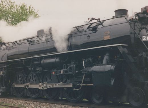 Side view of a black steam locomotive with a round CB&Q herald on its side, showing its number 26[?] and builder's plate from 1943.