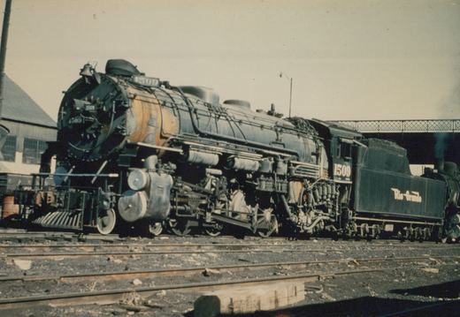 A black steam locomotive with the number 1509 and 'Rio Grande' lettering on its tender, parked on multiple tracks in a rail yard on a cloudy day.