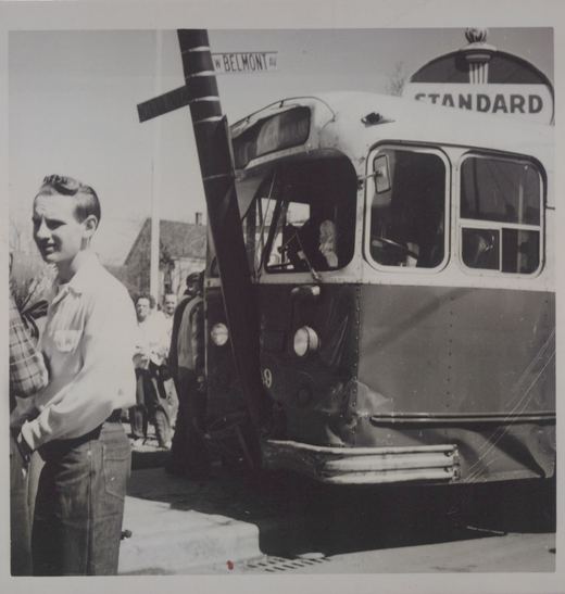 A black and white photo of a standard bus with number 49 at a street corner, with several people on the sidewalk.