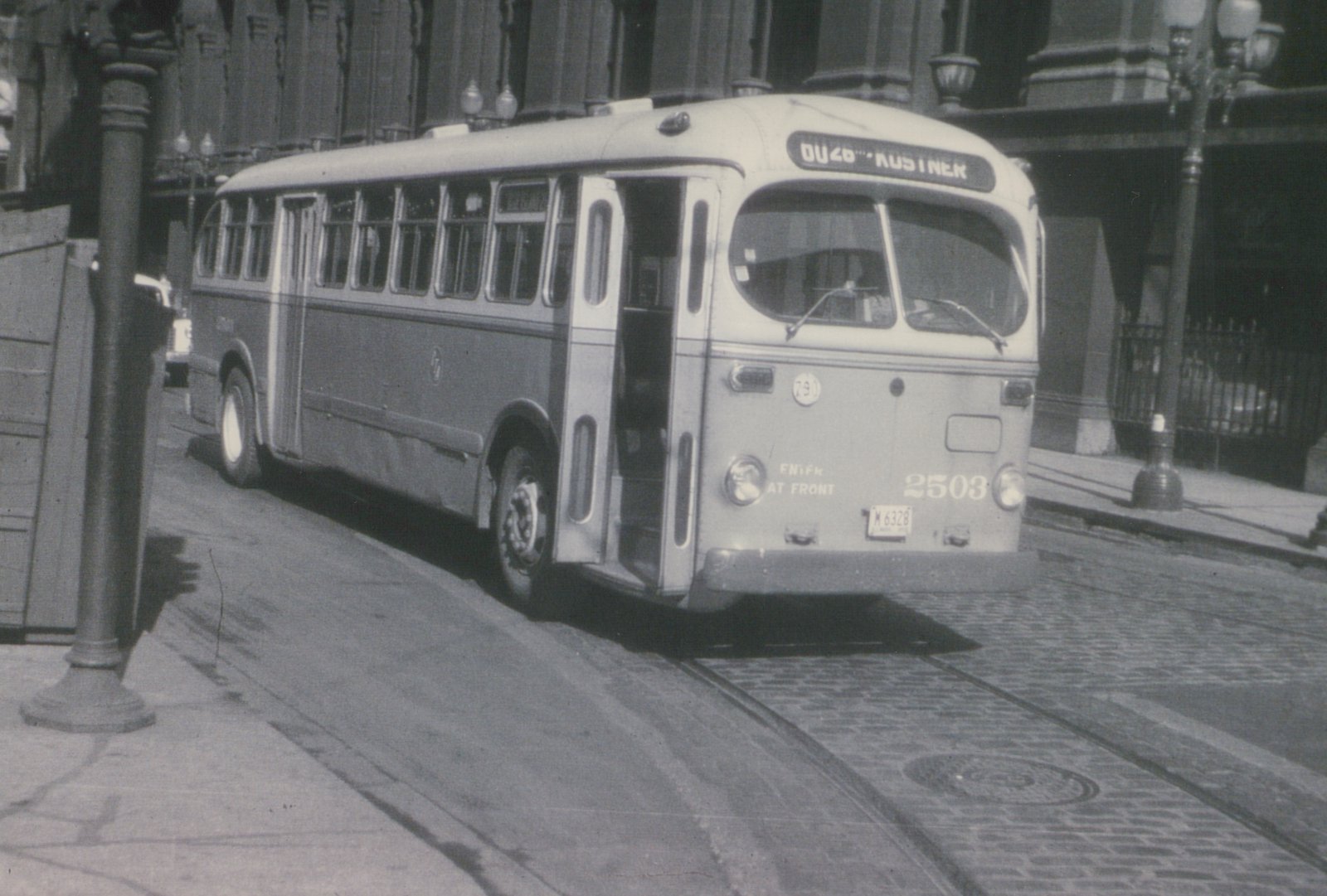 A black and white photo of a Chicago Transit Authority bus number 2503, a GM New Look model, parked on a cobblestone street with a destination sign reading DU46 KUSTNER.