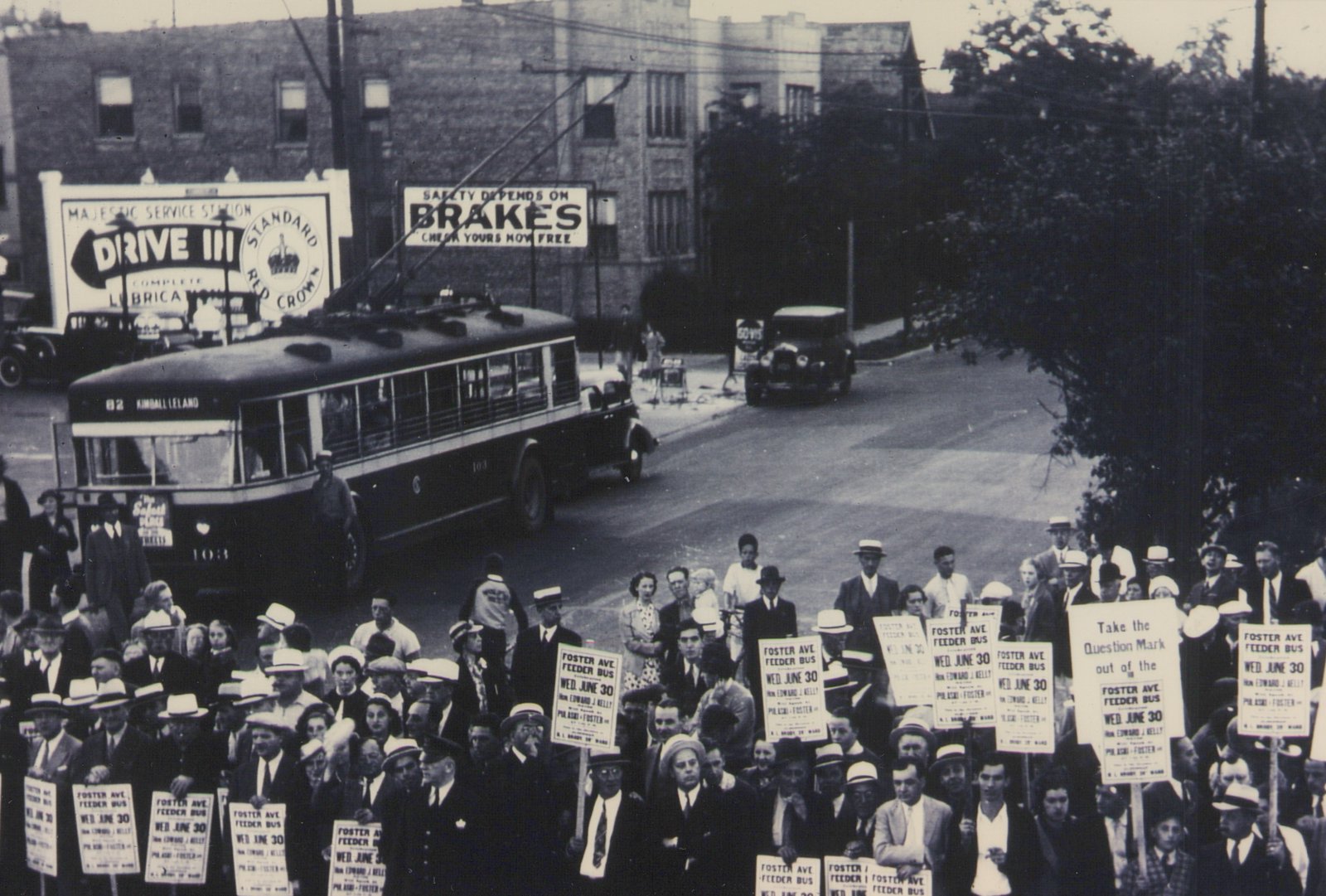 A black and white photo shows a trolleybus on a city street with a large crowd of people holding protest signs, one of which reads 'FOSTER AVE FEEDER BUS WED. JUNE 30', marking the last day of trolleybus service on that route.