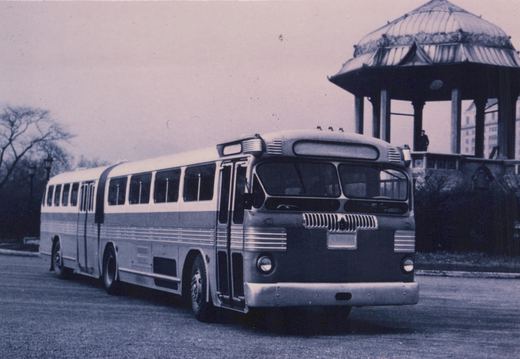 A vintage Chicago Transit Authority motor bus is parked on a street near a gazebo with bare trees in the background.