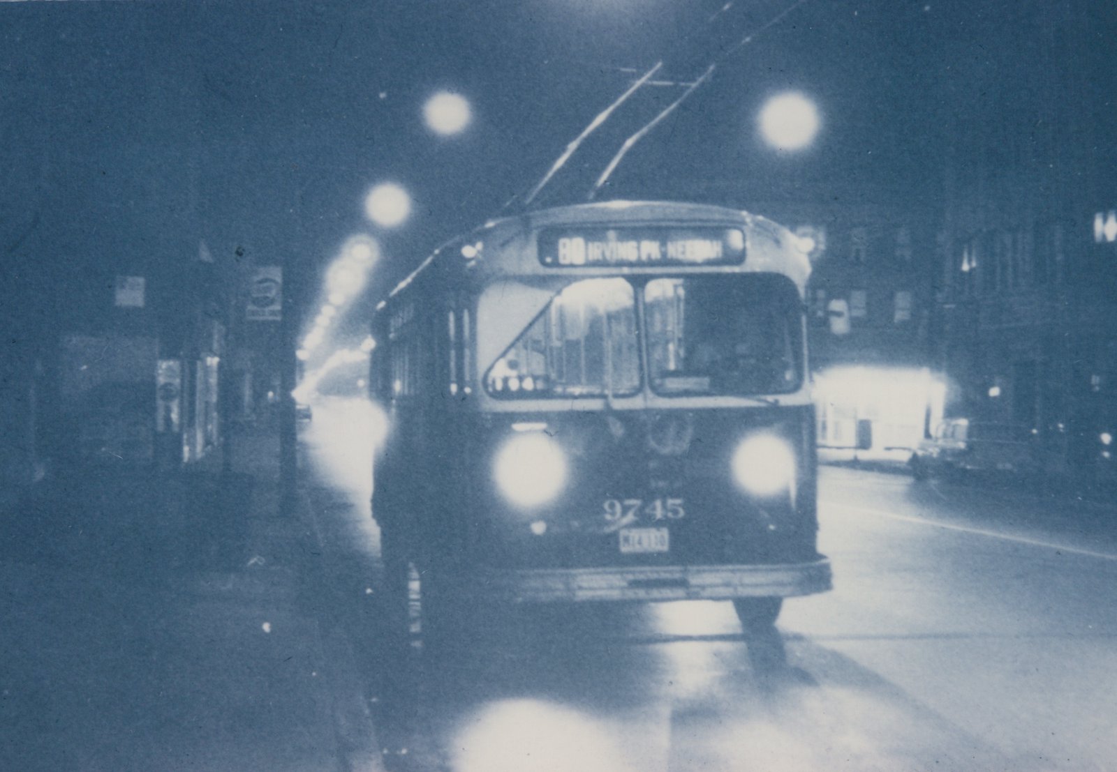 A front three-quarter view of a trolleybus at night on a city street, with its destination sign reading '80 IRVING PK-KEENAN' and fleet number 9745 visible.