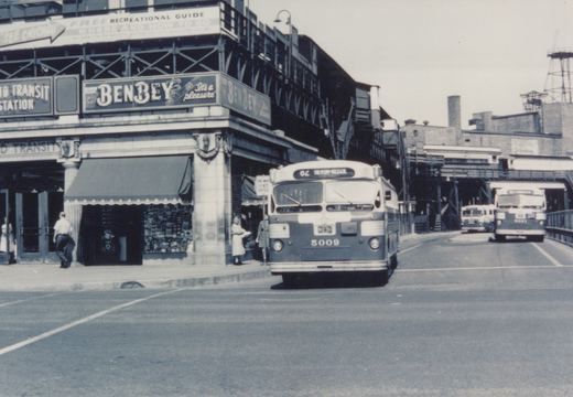 A vintage black and white photo of a Chicago Transit Authority bus on a city street, with a Ben-Bey sign on a building and other buses in the background.