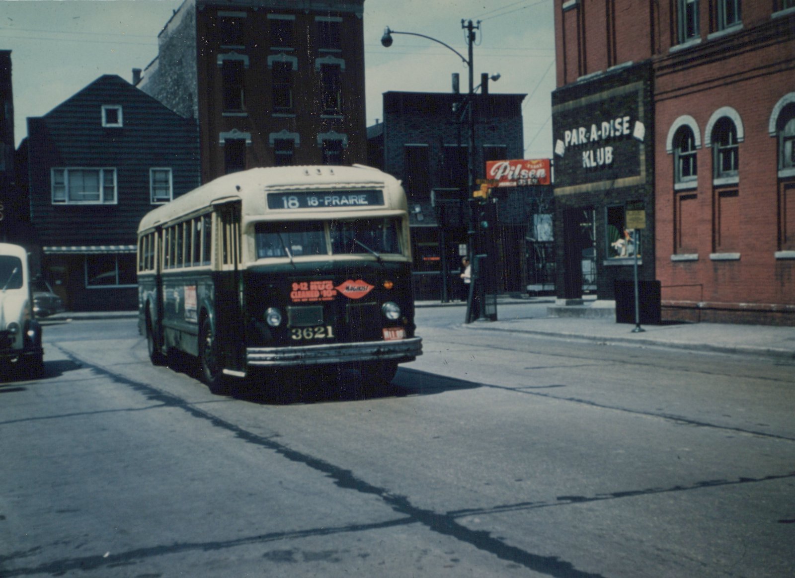 Front three-quarter view of a green and cream CTA bus number 3621 on a city street, with a sign for 'Par-A-Dise Klub' in the background.