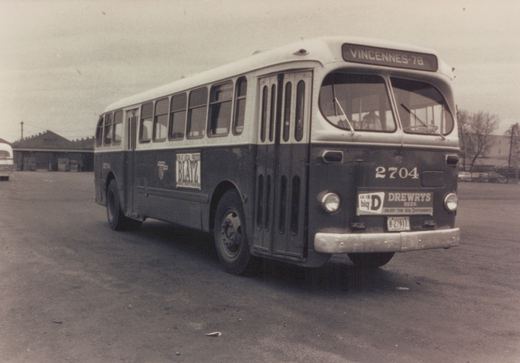 A dark blue and cream CTA bus, number 2704, with a Vincennes-78 route sign and Drewry's Beer advertisement on the front, parked on a paved lot with a building in the background.