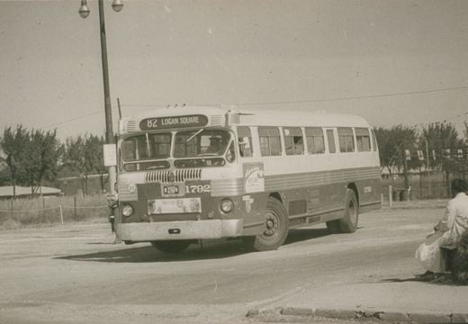 A vintage black-and-white photo shows a CTA motor bus, number 1792, on route 82 to Logan Square, parked on a street with a person waiting nearby.