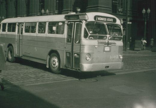 A black and white photograph shows a vintage CTA bus at a street corner, with its destination sign reading '7 MONROE-STATE' and the number 1605 on the front bumper.