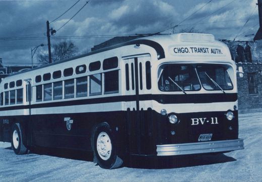 A black and white photo of a Chicago Transit Authority bus, model Flxible, with the fleet number BV-11, parked on a street on a cloudy winter day.