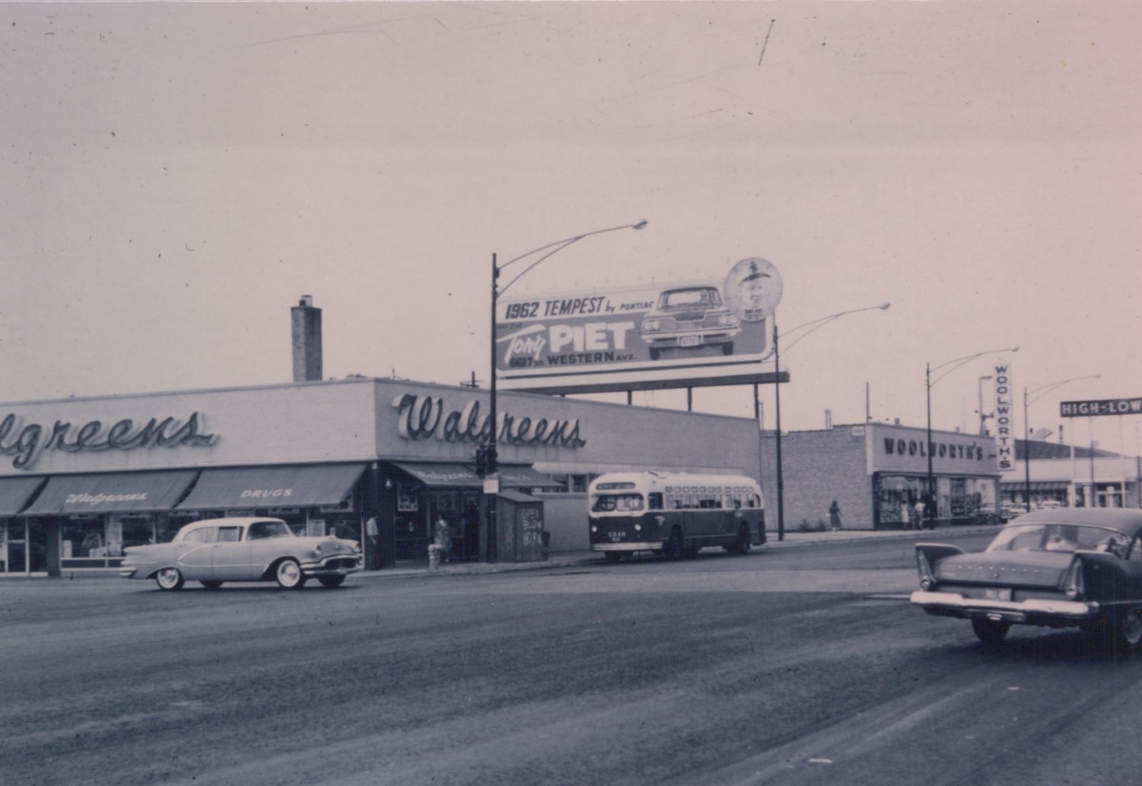A black and white photograph shows a Chicago Transit Authority bus at a busy street corner with Walgreens and Woolworth's stores, and a billboard advertising a 1962 Pontiac Tempest.