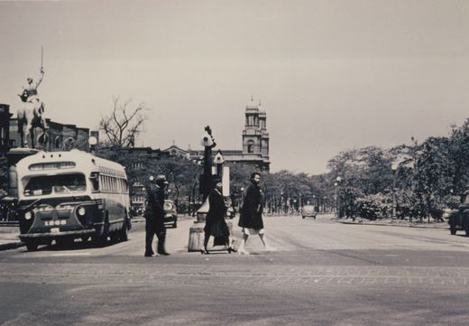 Black and white photograph of a Chicago Surface Lines motor bus, number 1268, stopped at an intersection with pedestrians crossing and a statue of a mounted rider in the background.