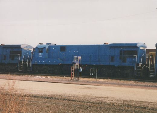 A blue Conrail diesel locomotive numbered 550 is parked on a railroad track in a yard, with another locomotive numbered 525 behind it, on a cloudy winter day.