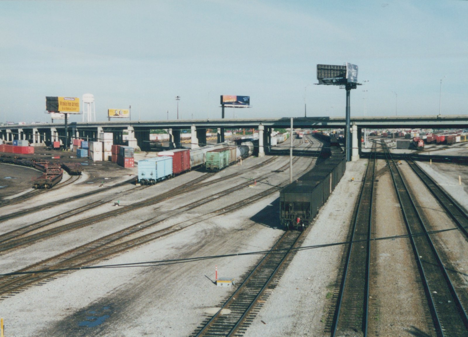 A high-angle view of a sprawling railroad yard with dozens of tracks, freight cars, and an overpass, located in Franklin Park, Illinois.