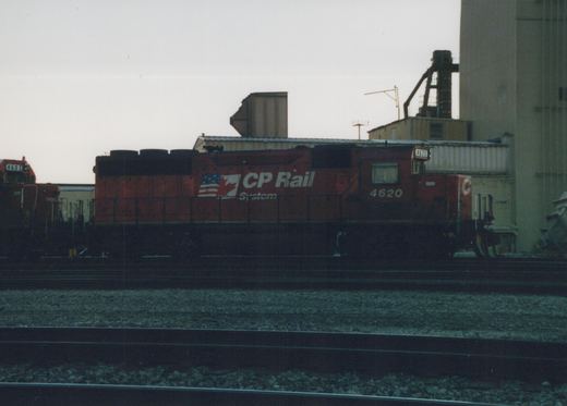 A red CP Rail locomotive with the number 4620 on its side and front, parked on tracks in a rail yard with another locomotive visible in the background.