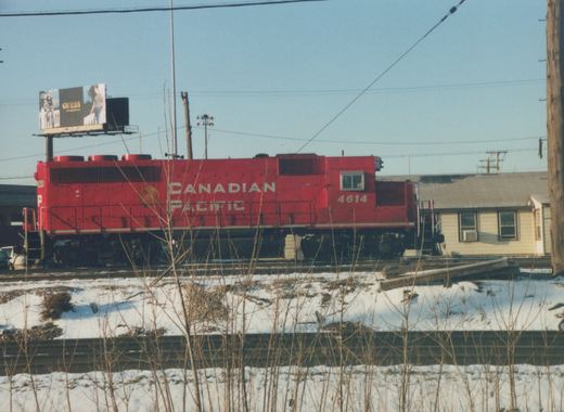 A red Canadian Pacific diesel locomotive numbered 4614 is parked on a railroad track in a snowy landscape.