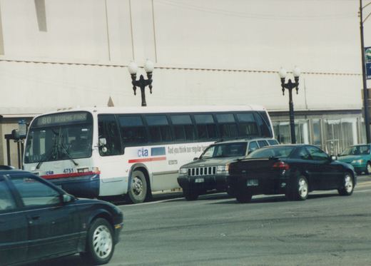 A white and blue Chicago Transit Authority bus, route 80 to Irving Park, number 4751, on a city street with cars around it.