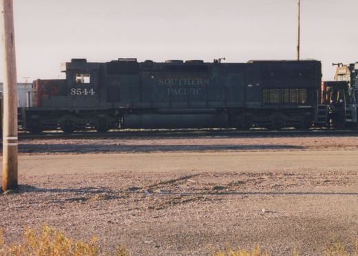 Side view of a Southern Pacific diesel locomotive, number 8544, in a gravel yard with another locomotive partially visible behind it.