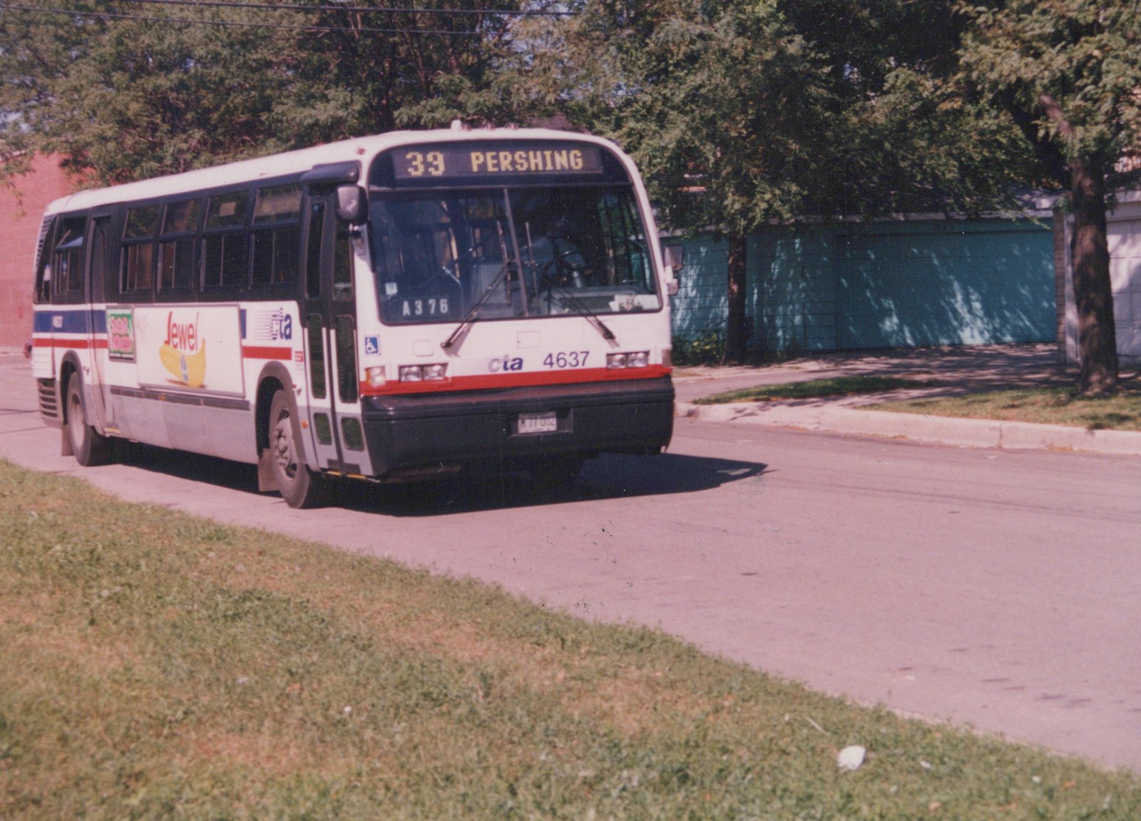 A white and red CTA bus with the number 4637 and route 39 Pershing is driving on a street with trees and a grassy area nearby.