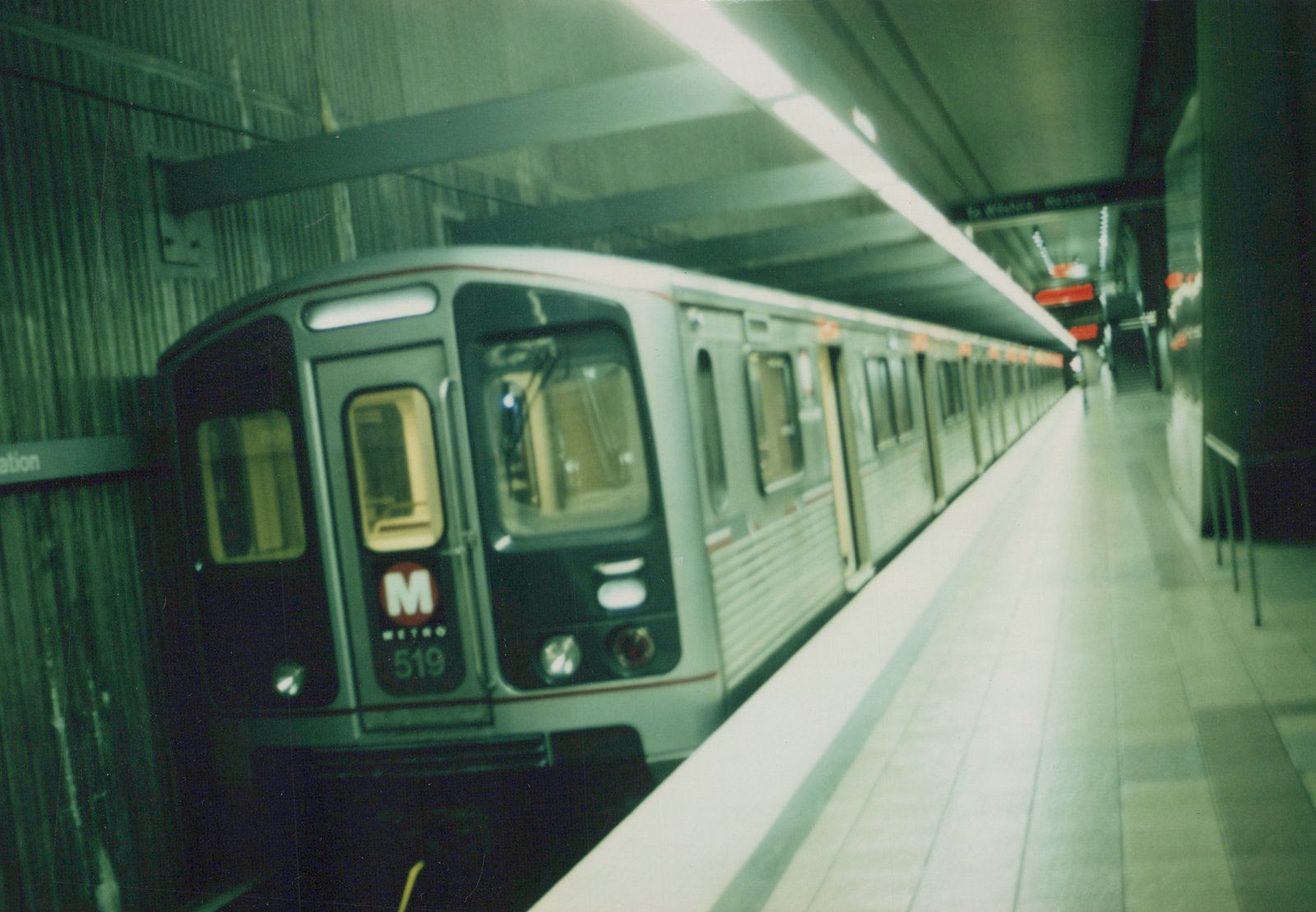 A silver CTA subway car with the number 519 and 'M METRO' logo is stopped at an underground station platform, with an overhead sign reading 'To Western - Western'.