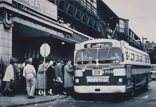 A vintage black-and-white photo of a Chicago Transit Authority bus, number 1799, stopped at a street corner with passengers boarding.
