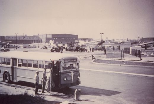 A vintage black-and-white photo of a Chicago Surface Lines bus numbered 348, with a destination sign reading 'CICERO-63', stopped at a curb with passengers and crew nearby. In the background are an American Airlines terminal and parked airplanes.
