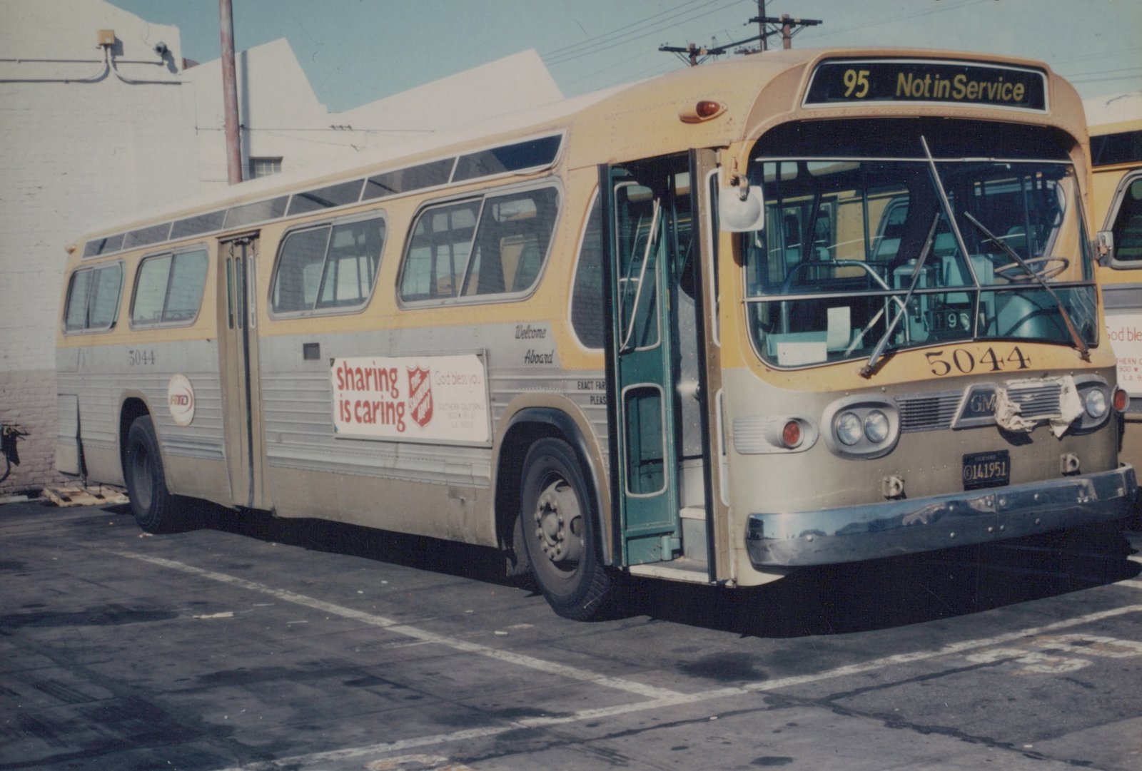 A cream and silver GM New Look bus, number 5044, operated by RTD, is parked with its doors open, displaying a 'Not in Service' sign on the front, and a Salvation Army ad on the side.