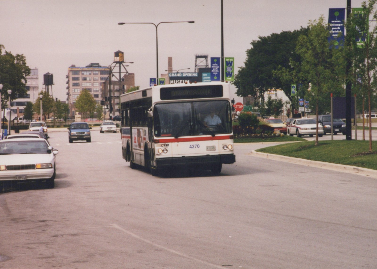 A white and red Chicago Transit Authority bus, number 4270, is driving on a city street with a destination sign reading 'MUSEUM/SOUTH DEREK'. Other cars and a water tower are visible in the background.