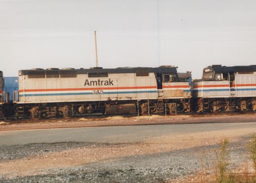 Two Amtrak EMD F40PH diesel locomotives, numbered 345 and 319, are shown side by side in a gravel yard, displaying their distinctive red, white, and blue Phase I/II livery.