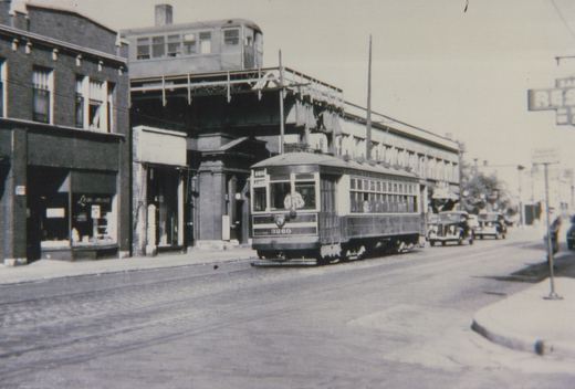 A black-and-white street scene from the 1930s showing a Chicago Surface Lines streetcar numbered 3260 on the street, with a Chicago Rapid Transit Company elevated car visible on the structure above.
