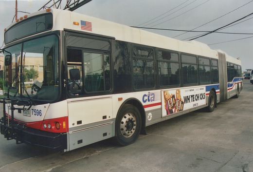 A white, red, and blue Chicago Transit Authority articulated bus numbered 7596 is parked on a street under an overcast sky, with a movie advertisement on its side.