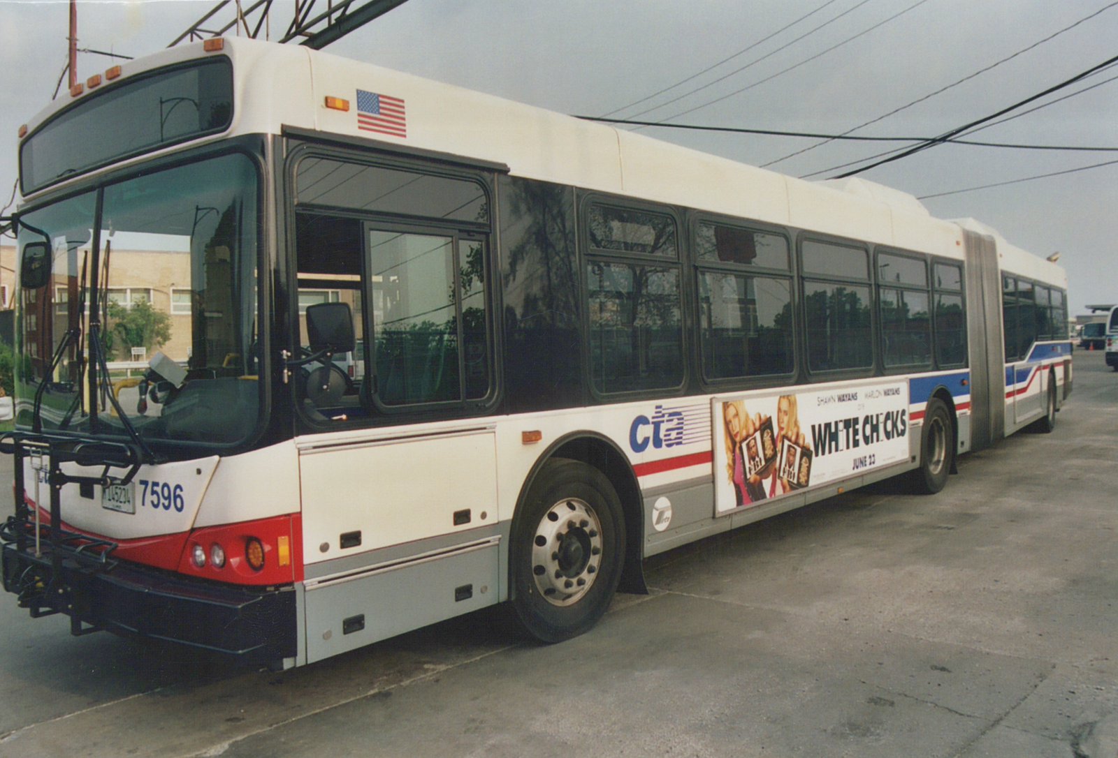 A white, red, and blue Chicago Transit Authority articulated bus numbered 7596 is parked on a street under an overcast sky, with a movie advertisement on its side.