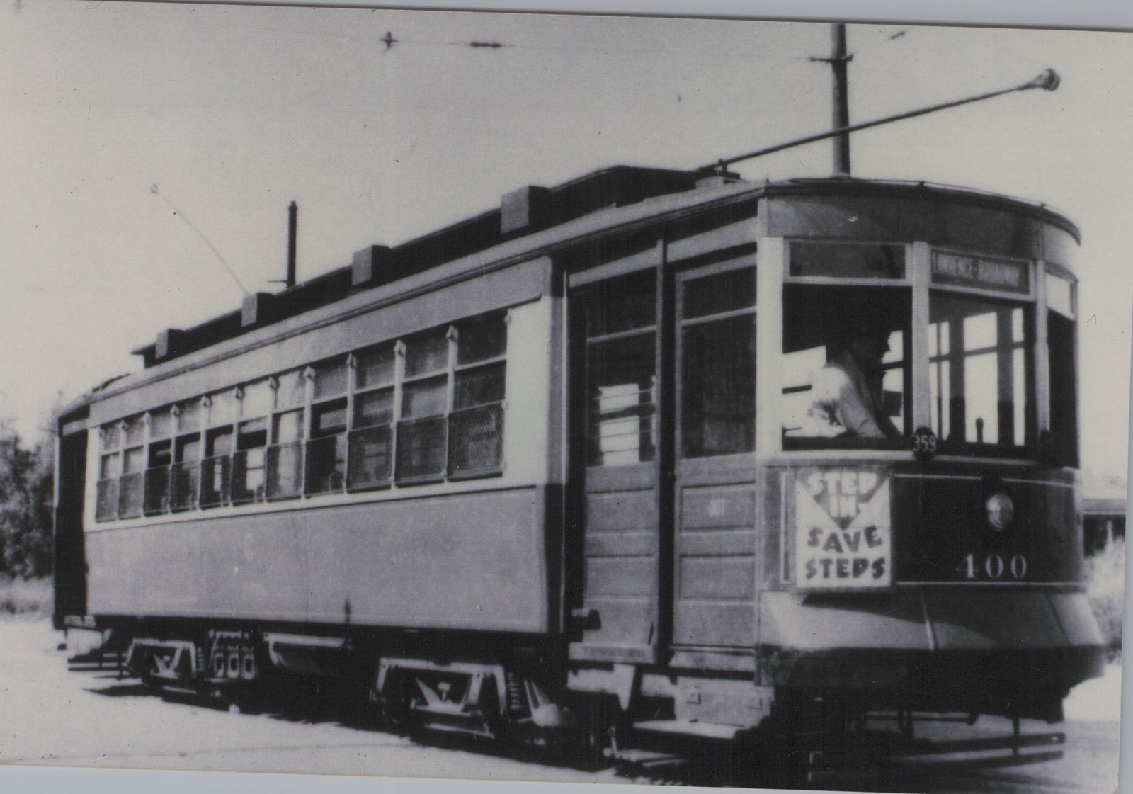 A black-and-white photograph of a vintage Chicago streetcar with the number 400, showing a driver inside and the destination sign reading 'LAWRENCE - BROADWAY'.