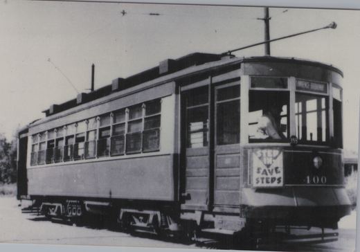 A black-and-white photograph of a vintage Chicago streetcar with the number 400, showing a driver inside and the destination sign reading 'LAWRENCE - BROADWAY'.