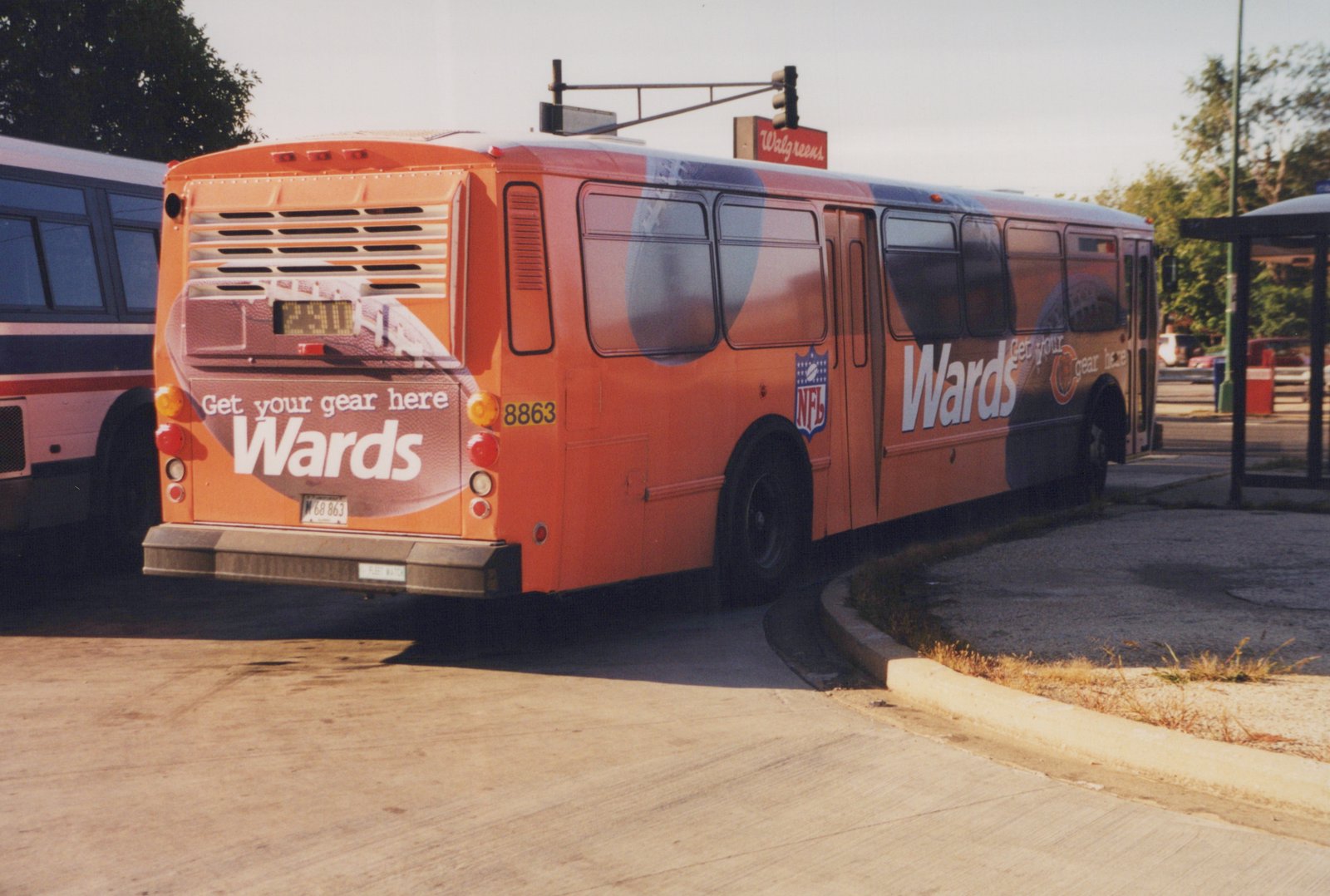 An orange CTA bus with a Wards ad on its side and rear, showing fleet number 8863 and route 280, parked at a curb next to a bus stop with a Walgreens sign in the background.