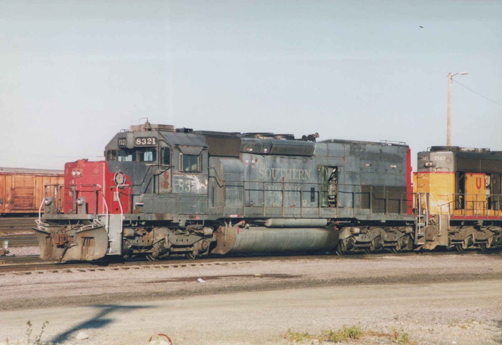 Two diesel locomotives, one Southern Pacific and one Union Pacific, are coupled together in a rail yard.