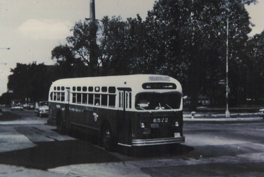 A black and white photo of a Chicago Transit Authority New Look bus, number 6572, on a city street with trees and cars in the background.