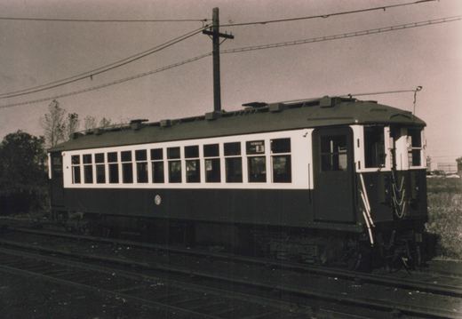 A black and white photograph of a vintage interurban car, numbered 4, with a destination sign reading 'HOWARD B', on a set of tracks with overhead wires and a wooden utility pole in the background.